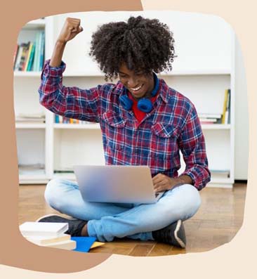 teen working on a laptop while sitting on the floor